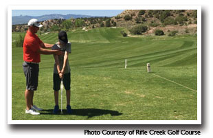 A young man gets a golf lesson from instructor at Rifle Creek Golf Course, Colorado, Photo Courtesy of Rifle Creek Golf Course