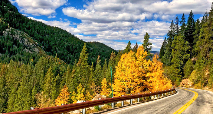 Driving along a Colorado Scenic Byway with beautiful early fall colors along the highway.