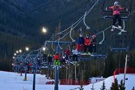 People on illuminated ski lift for some night skiing Echo Mountain Ski Resort in Idaho Springs, Colorado.