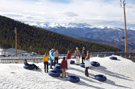 People with their quick tubes at the top of the tubing hill conveyor at Echo Mountain Ski Resort in Idaho Springs, Colorado.
