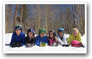 Kids laying in snow at Granby Ranch Resort, Colorado.