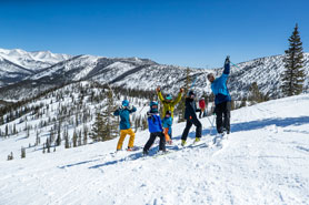 Family of Skiiers waving on the summit of Monarch Mountain Ski and Snow-Boarding Resort, Colorado. Photo Courtesy of Creekside Chalets and Cabins.