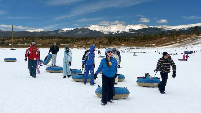 Group of people bundled up and having fun Snow tubing at Colorado Adventure Park in Winter Park, Colorado