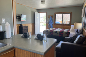 Indoor view of family cabin with queen size bed, recliner flat screen tv and kitchenette at Healing Waters Resort and Spa near Durango in Pagosa Springs, Colorado.