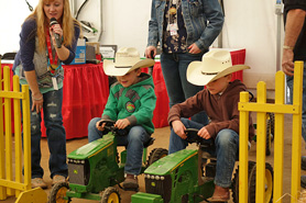 Kids on mini-tractors getting ready to race at the National Western Stock Show in Denver, Colorado