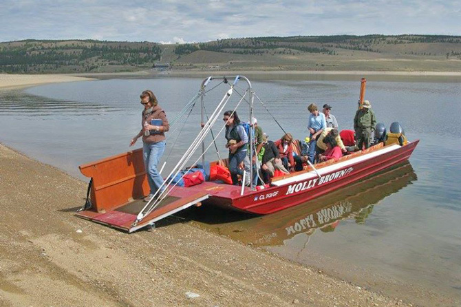 People getting off a boat on the shore of the Twin Lakes with Twin Lakes Interlaken Boat Tours. Boat Tour of Twin Lakes with a Guided Walking Tour of Old Interlaken Resort. Along the Collegiate Peaks Scenic Byway on CO Highway 82.