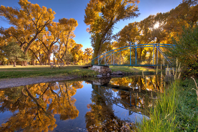 Fall colors at walking bridge over river near Twin Rivers Cabins and RV Park in Antonito, Colorado.