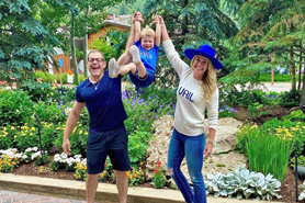Family having fun holding up child in front of a beautiful garden at Beaver Creek and Vail Vacation Rentals. Located in the Vail and Beaver Creek valley of Colorado.