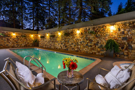 Outdoor hot tub and pool lit up during the evening at Vail's Mountain Haus at the Covered Bridge located in Vail, Colorado.