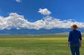 Person looking out over the plains to the mountains near Westcliffe, Colorado.