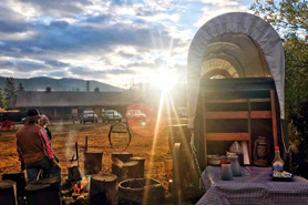 Beautiful sunrise setting at a chuckwagon breakfast with campfire and settler-pioneer wagon at Winding River Resort near Grand Lake, Colorado. Winding River Resort Village, A Family Reunion Destination serving Chuckwagon Meals.